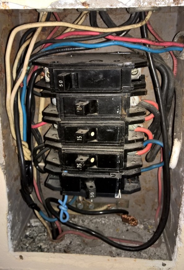 Quadro elétrico antigo com fiação inadequada em residência no Rio de Janeiro